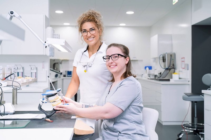 Zahnarzt und Zahntechniker arbeiten zusammen an einem Modell