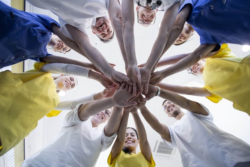 Teamfoto mit allen Händen in der Mitte