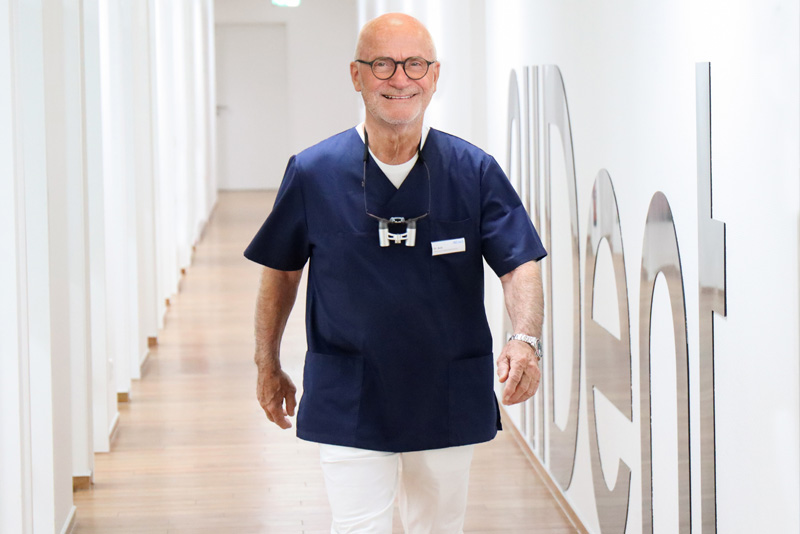 Dr. Wolfgang Bolz läuft Gang entlang auf Kamera zu